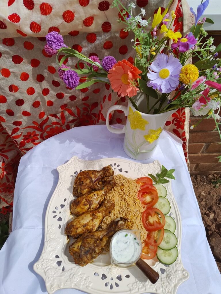 Golden air fryer chicken drumsticks served over noodles with fresh tomato and cucumber salad