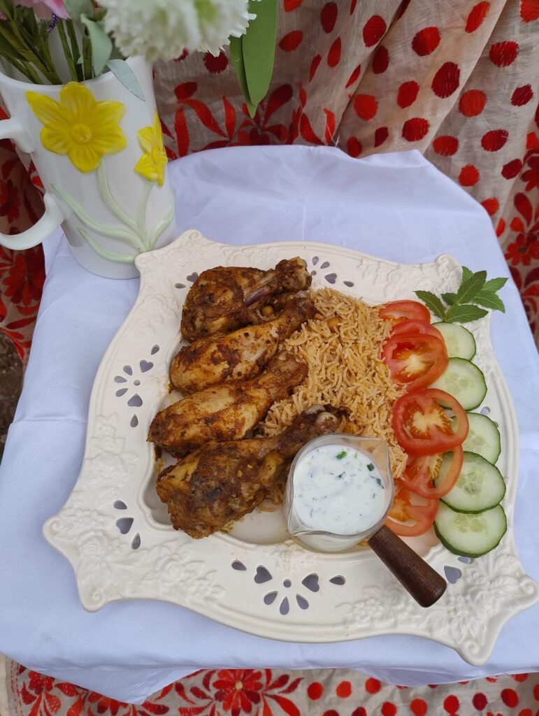 Plated air fryer chicken drumsticks with rice and fresh vegetable garnish