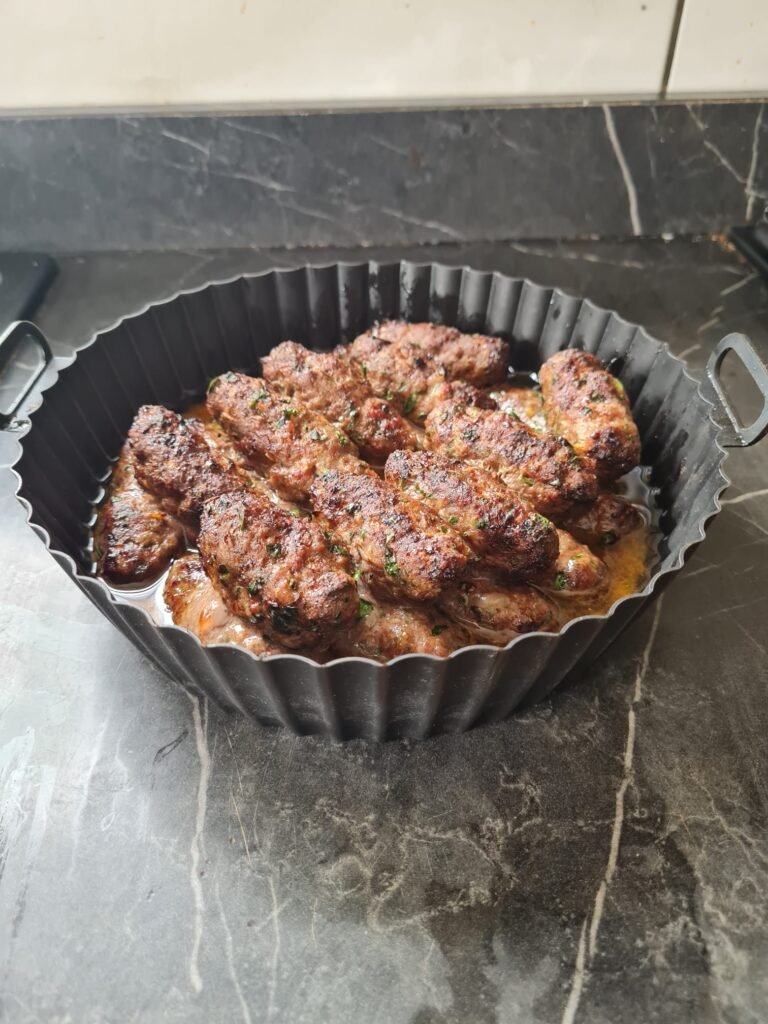 lamb kofta in air fryer basket during cooking